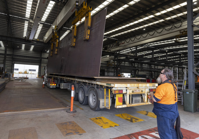 Man loading the steel metal on the truck using a freight lifter