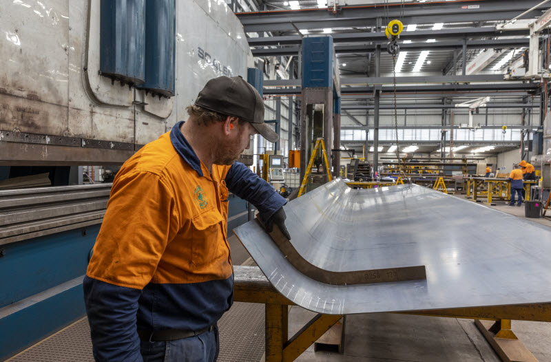 Man checking the measure of the steel plate