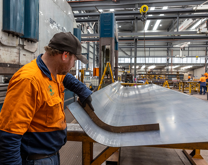 Man measuring steel inside a factory